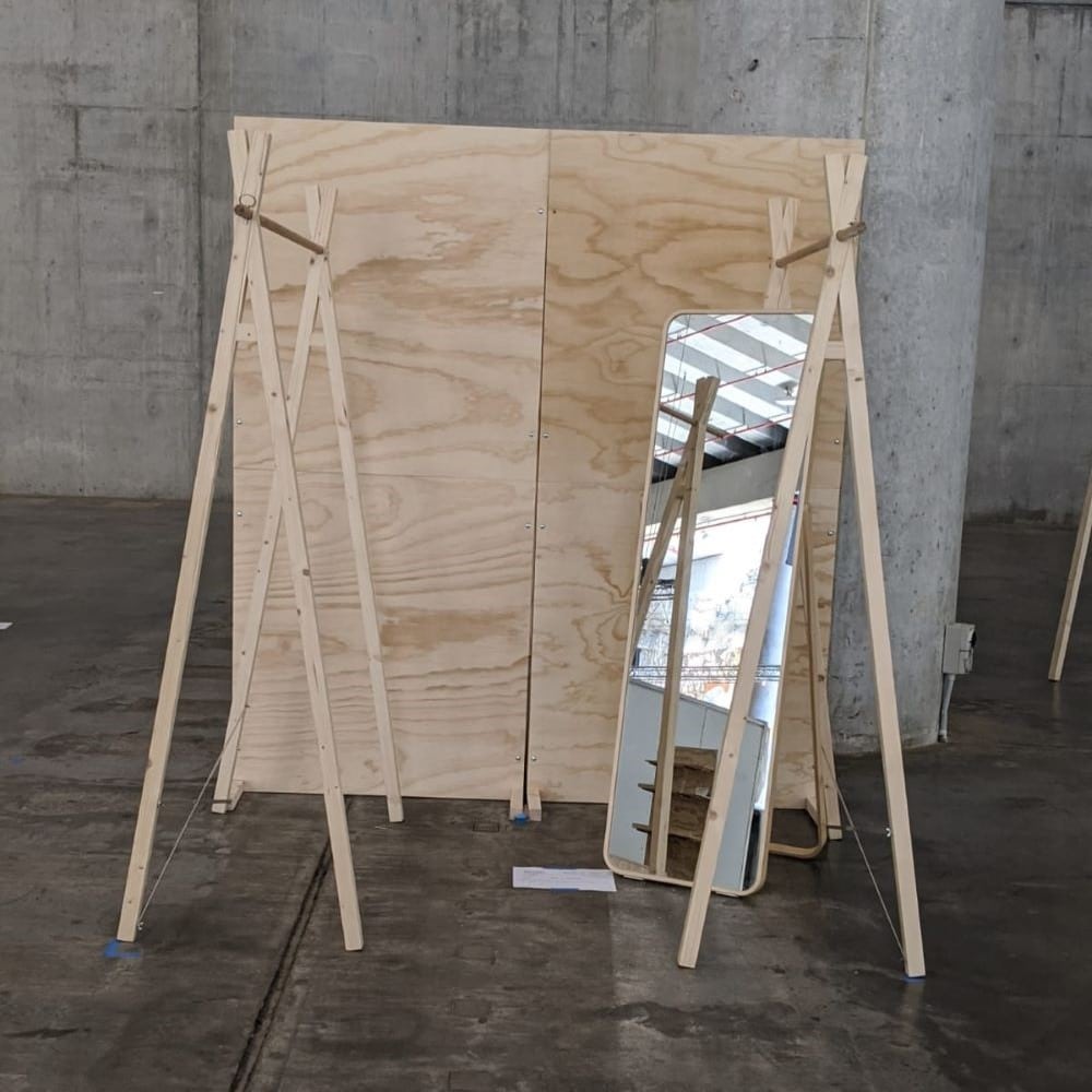 floorplan including ply walls, hanging a-frame clothing racks and a freestanding mirror