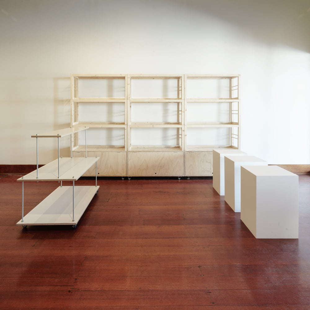 Floorplan with three stacked shelving units, one white centered floating stand and three white plinths