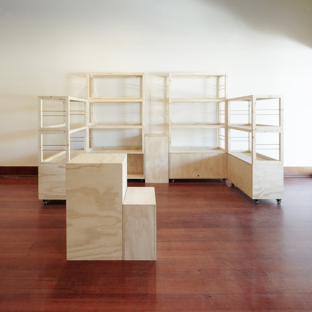 four stacked shelving units, one plywood plinth and one mini counter