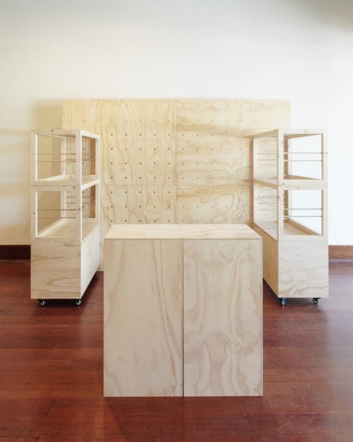 two freestanding pegboards, two stacked shelving units two shelves high and two plywood plinths