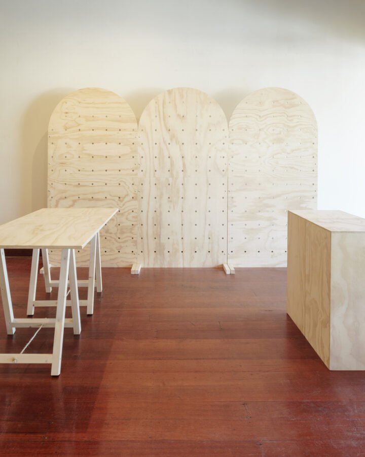 three freestanding arch pegboards, a trestle table and one enclosed counter